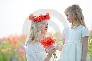 child giver flowers to his mom. Outdoors family portrait daughter with mother