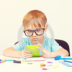 Child in glasses doing homework at home. Back to school concept