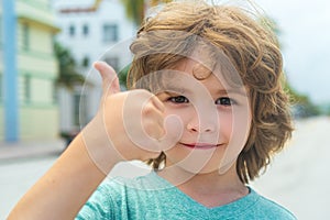A child with glasses gives a thumbs-up. A kid likes the glasses. Little boy approves. Portrait of a smiling little boy