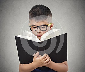 Child with glasses reading book