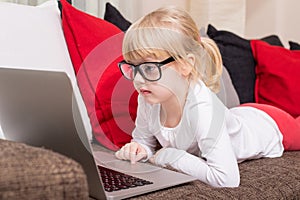 Child with glasses using computer