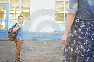 The child goes to school. boy schoolboy goes to school in the morning. happy child with a briefcase on his back and textbooks in