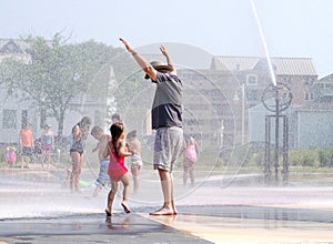 Child and grandpa playing at the whirlpool fountains