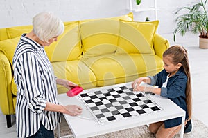 Child and grandparent playing checkers game