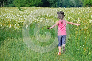 Child on green spring meadow, kid running and having fun