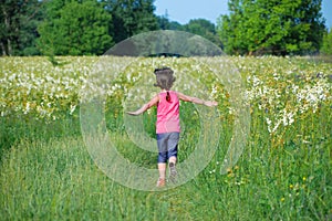 Child on green spring meadow, kid running and having fun