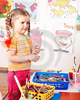 Child with group of colour pencil in play room.