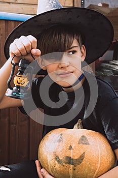 Child in Halloween costume with pumpkins, and lamp