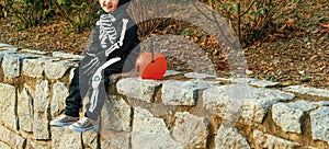 Child with Halloween pumpkin Jack Oâ€™Lantern basket on parapet