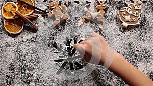 Child hand drawing big snowflake in the flour prepared