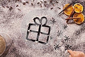 Child hand drawing christmas present and twinkling stars in the