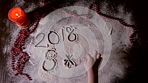 Child hand drawing in the flour