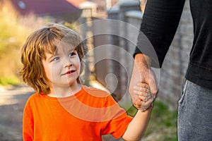 Child hand father. Hands of parent and child outdoors. Parent holds the hand of a small child. Father& x27;s hand lead