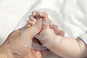 child hand holding fathers thumb