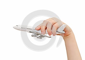 Child hand holding model airplane.