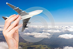 Child hand holding model airplane.