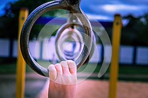 Child hand holding monkey bar.