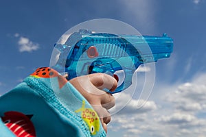 Child hand holding toy gun / water pistol