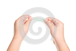 Child hand playing with elastic rubber band isolated on white photo