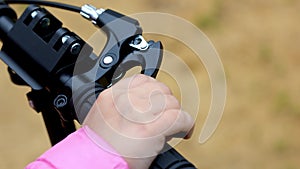 Child hand pressing brake on a scooter.