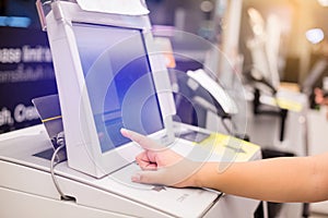 The child hand is pressing the screen of the automatic payment machine.