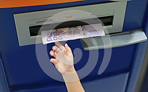 Child hand receive money from ATM