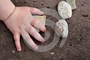 Child hand touching a stone
