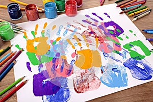 Child handprints and art equipment, school desk, classroom