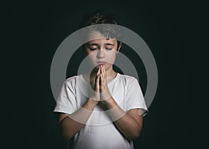 Child with hands clasped together praying