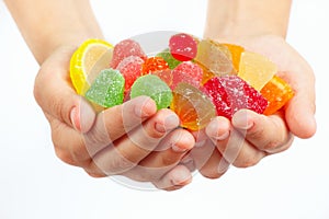 Child hands with colorful fruity sweets and jelly close up