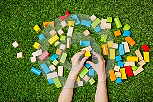 Child hands constructing from color wooden blocks