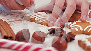 Child hands decorating a pine tree shaped christmas cookie