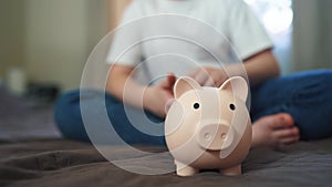 child hands hoarding coins put in a piggy bank. happy family accumulation business concept. child saving coins in a