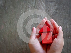 Child hands holding red model house, family, homeless, home loan and home protect insurance concept. Home sweet home