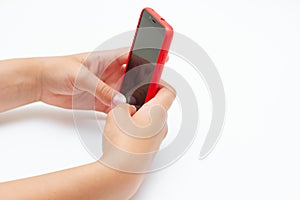 Child hands holding a smartphone with red cover case. Free space