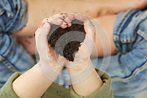 Child Hands Holding Soil in Heart Shape