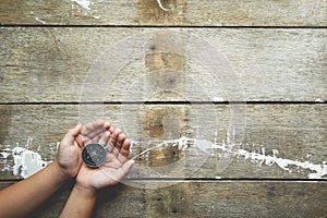 Child hands holiding compass on wooden