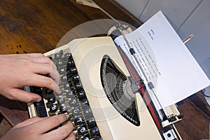 Child hands on keyboard of old portable typewriter