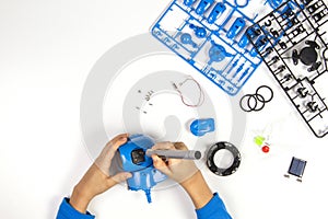 Child hands making blue robot. Robotic, learning, technology, stem education for children background