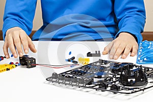 Child hands making robot car. Robotic, learning, technology, stem education for children background