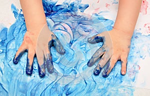 Child hands painted in blue paint