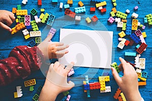 Child hands playing with colored toy bricks