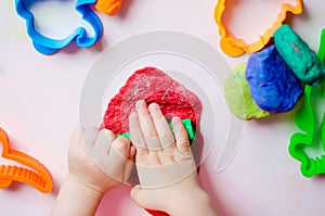 Child hands playing with colorful clay. Homemade plastiline