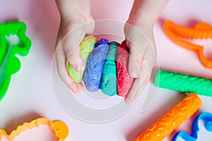 Child hands playing with colorful clay. Homemade plastiline