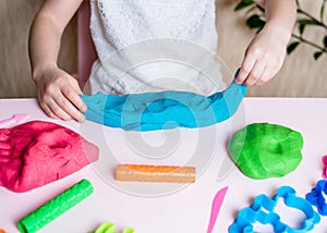 Child hands playing with colorful clay. Homemade plastiline. Plasticine.