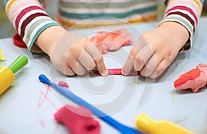 Child hands playing with colorful plasticine during quarantine Covid-19