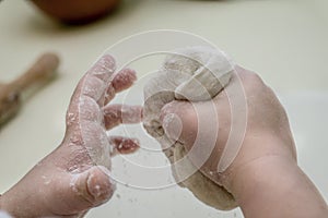 Child hands playing with dough.