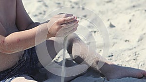 child hands playing sand sitting on beach sunny day, white sand pouring through