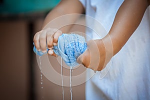 Child hands squeeze wet blue towel p