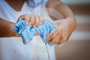 Child hands squeeze wet blue towelp